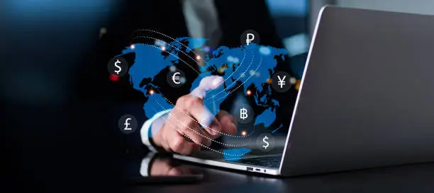 Photo of Currency exchange, money transfer, FinTech financial technology, global company, internet banking, interbank payment idea, man utilizing laptop computer with foreign currencies