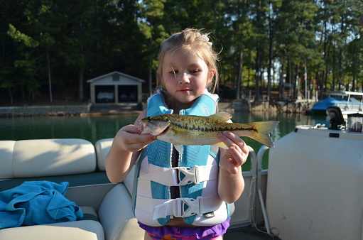 Little girl enjoying lake life, fishing for bass, Lake Martin, Alabama