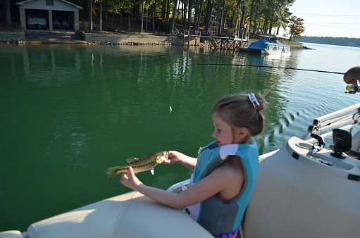 Little girl enjoying lake life, fishing for bass, Lake Martin, Alabama