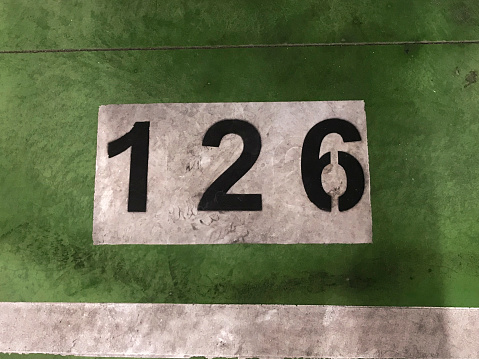 number painted in white on a green background on the floor of a subway parking garage
