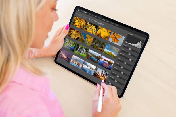 istock Woman viewing digital photo files and editing photos on tablet computer 1422817848