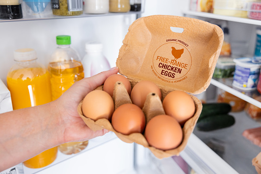 Woman holding package of free range chicken eggs