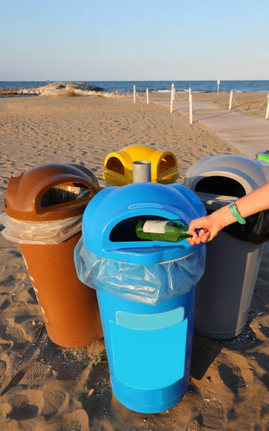 istock waste bin for separate collection on the beaches and a hand 1422818088