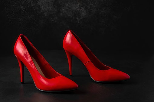 bright red high-heeled shoes stand on a dark background