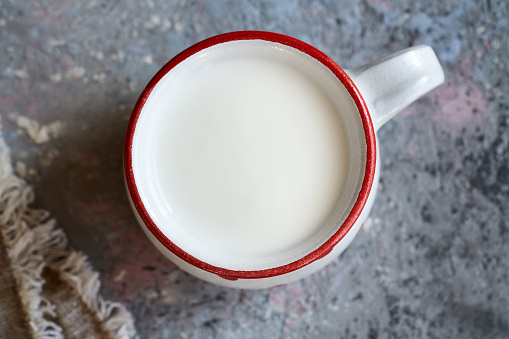 Fresh milk kefir in a red and white cup, top view