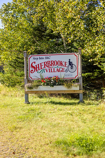 Sherbrooke, Canada - August 28, 2022. A sign directs visitors to Sherbrooke Village, a commemoration of 1860s Nova Scotia.