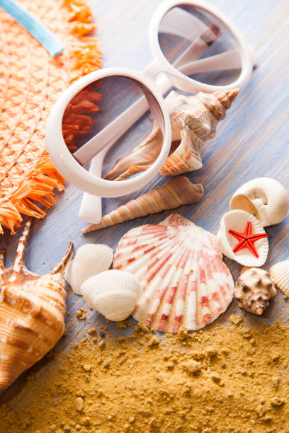 istock beach accessories glasses hat cockleshells on wood deck. 1422822853