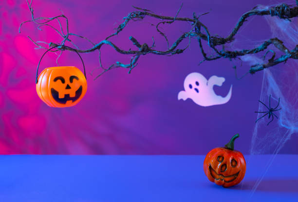 istock Halloween decorations with pumpkins, spider, spider web, ghost and bat on neon background. Halloween party concept. 1422822994