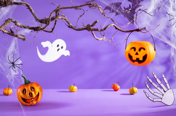 istock Halloween decorations with pumpkins, spider, spider web, ghost and bat on purple background. Halloween party concept. 1422822997