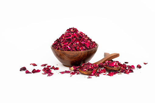 Dry Red Rose Petals in wooden bowl isolated on white background