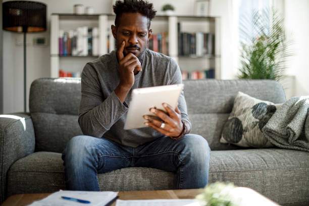 istock Worried man using digital tablet to calculate budget and finances 1422826919