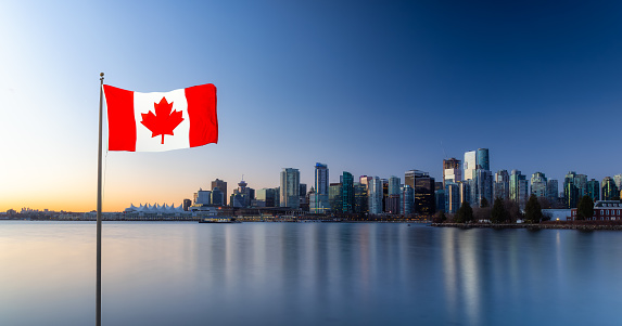 Canadian National Flag Composite. Panoramic View of Modern City Building Skyline on West Coast Pacific Ocean. Winter Sunrise. Stanley Park, Coal Harbour, Downtown Vancouver, British Columbia, Canada.