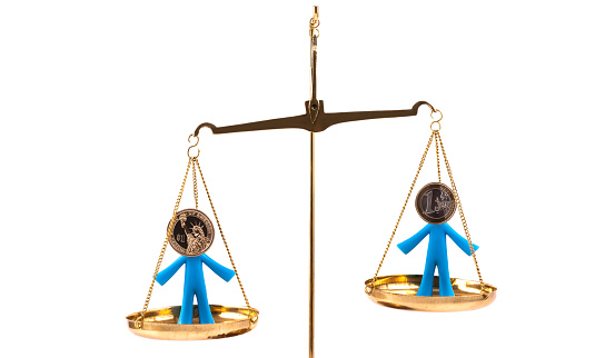 Figurines of symbolic people with coins of 1 euro and 1 US dollar instead of heads on the scales