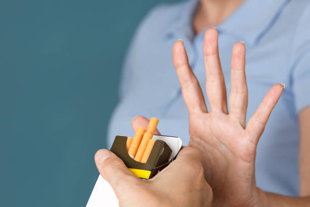 Woman hand refusing cigarette offer. Quitting smoking concept. stock photo