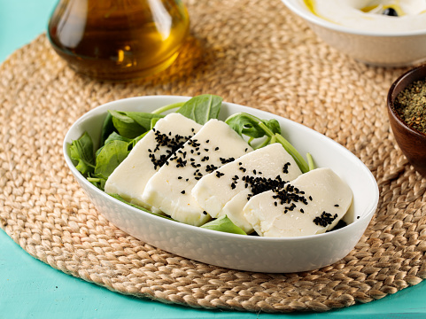 Grilled Halloumi Cheese served in dish isolated on wooden table side view of middle eastern food