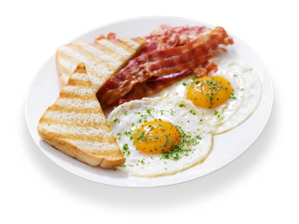 Breakfast sandwiches whole grain bread with fried egg, tomato, bacon, cream cheese on a light background, top view