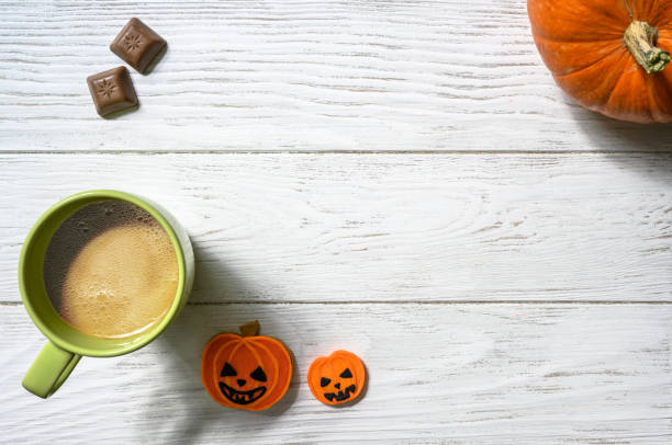 istock Halloween and coffee theme, orange pumpkin, sweets and cup on white table 1422840919