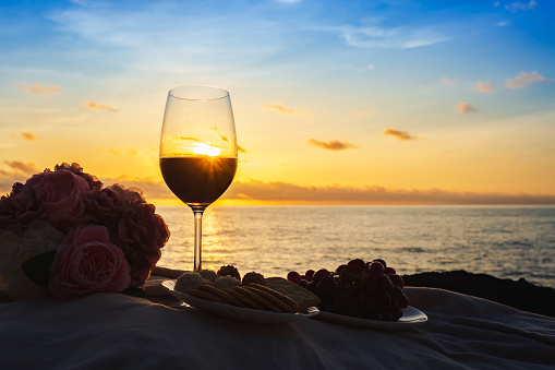 Grape juice in wine glass and bread Holy Communion\non the natural background At sunset, silhouette style