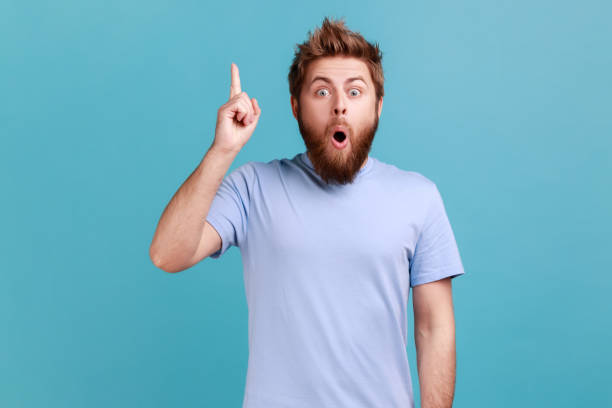 istock Man in blue T-shirt pointing finger up, has good idea genius plan, inspiration and creativity. 1422844202