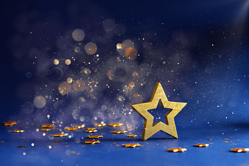 Golden Christmas star on a defocused blue background with bokeh