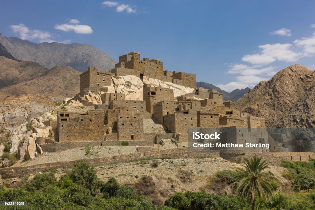 Panoramic view of Thee Ain (Dhee Ayn) heritage village in the Al-Baha region of Saudi Arabia The village of Thee Ain is in the Al-Mikhwat province of the Al-Baha Region, Saudi Arabia. The village is characterized by houses built from polished stones. Ancient Stock Photo