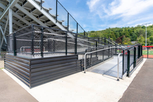 istock Accessible wheelchair ramp with railings and slip resistant surface at empty metal stadium bleacher.	 Nondescript location with no people in image.  Not a ticketed event. 1422852973