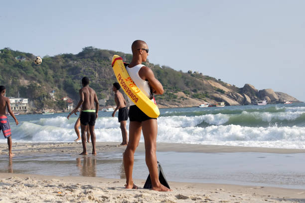man saves lives attentive to bathers on the beach - lifeguard association imagens e fotografias de stock