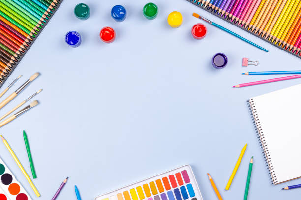 istock Creative art work supplies background. Watercolor, brushes, pencils, notebook on blue background. Top view, flat lay 1422854851