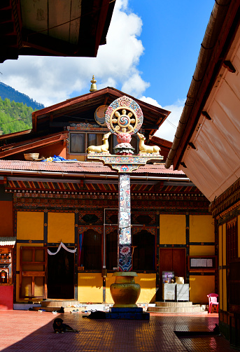 Zilukha, Thimphu, Bhutan: Dharma wheel (dharmachakra) on a column at Thangthong Dewachen Dupthop nunnery,  built by the 16th emanation of Thangtong Gyalpo, Drubthob Rikey Jadrel - Vajrayana Buddhism.