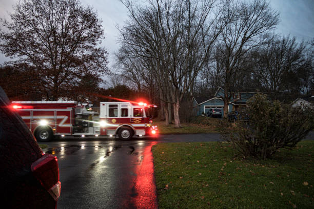 istock Fire Engine with Flashing Emergency Lights Rushing Through Suburban Neighborhood 1422863311