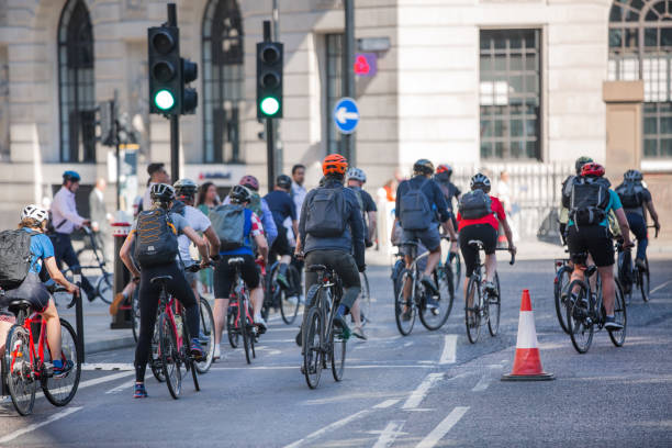 People cycling at work by bike and make a spot by the traffic lights. People cycling into the City of London stock photo