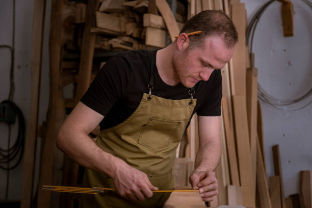 istock Carpenter mature man drawing on wood 1422866653