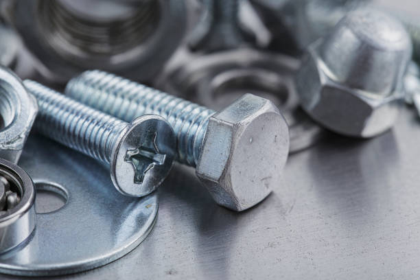 set of different nuts, bolts, screws, washers and drill bits,thread tap and mill cutters on steel plate background. Locksmithing deal.