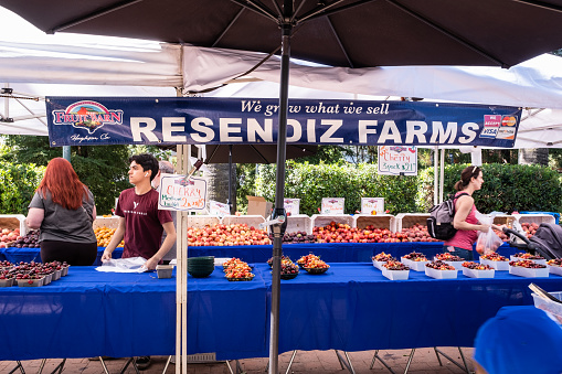 Vacaville, CA - May 21, 2022: Shoppers and workers at a fruit vendor at the Vacaville Farmer's Market.