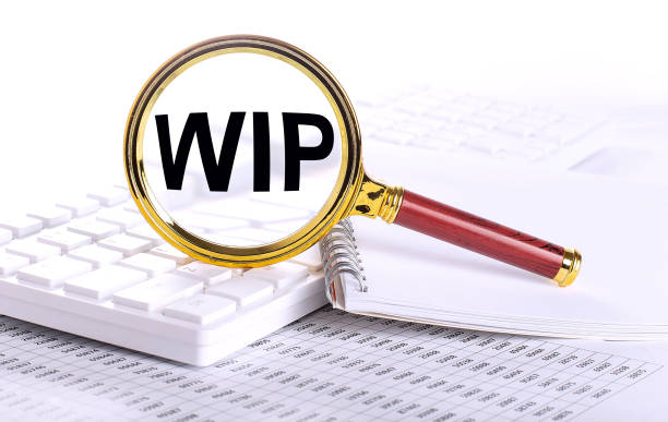 istock WIP - Work In Progress word through magnifying glass on keyboard on the chart, business 1422871952
