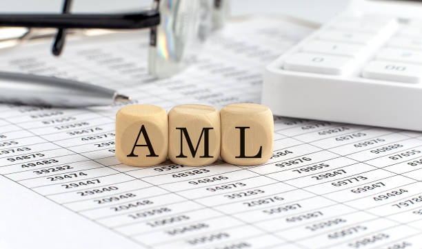 wooden cubes with the word AML stand on a financial background with chart, calculator, pen and glasses, business concept. stock photo