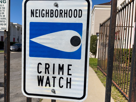 Neighborhood crime watch sign on a fence