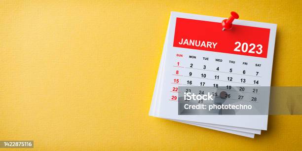 White Sticky Note With 2023 January Calendar And Red Push Pin On Blue Background Stock Photo - Download Image Now