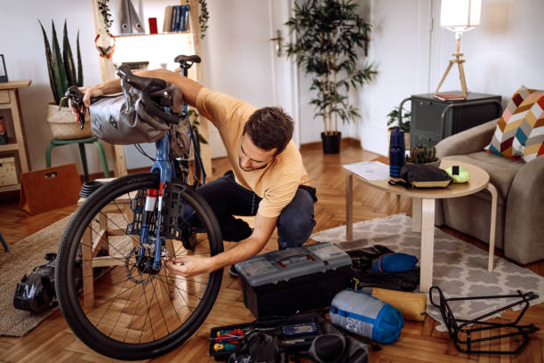 istock Young handsome man getting his bicycle ready for a ride at his home 1422876408