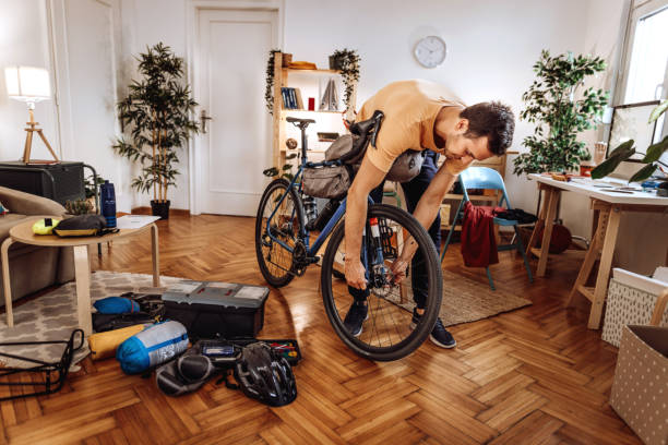 istock Young handsome man getting his bicycle ready for a ride at his home 1422876428
