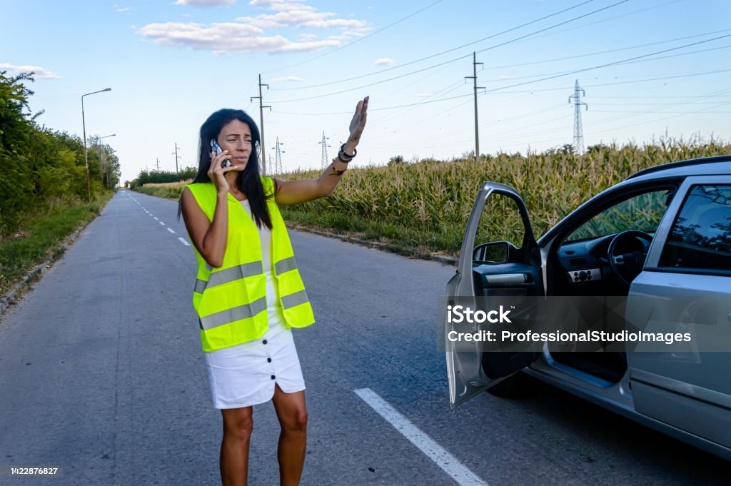 Young Woman had a Car Accident and is Calling a Serice. A Woman had a Traffic Accident on a Road and Using her Mobile Phone to Call Car Service. Car Stock Photo