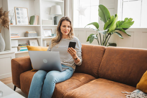 istock Mature woman using laptop on sofa 1422884461