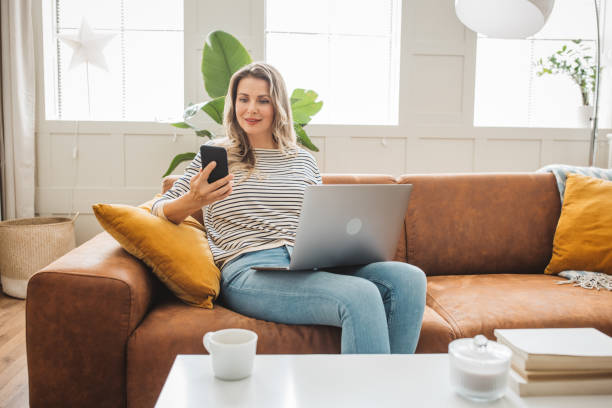 istock Mature woman using laptop on sofa 1422884480
