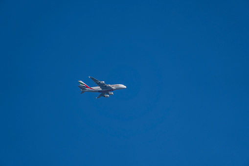 An Emirates Airbus A380 flying in blue skies on its way to Manchester Airport, UK from Dubai