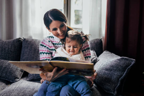 istock Christmas Stories: Mother Reading a Book to Her Daughter 1422890144