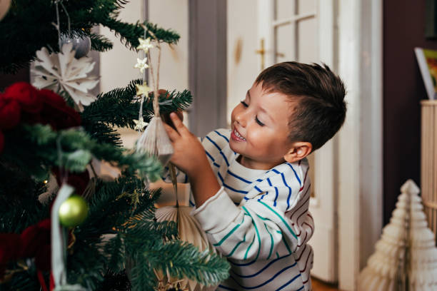 Family Christmas: a happy boy decorating the Christmas tree with the help of his father.