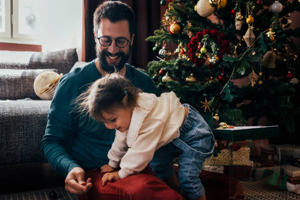 istock Smiling Man Playing With His Daughter at Christmas 1422890259