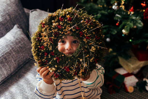 Portrait of a smiling by holding a Christmas wreath.