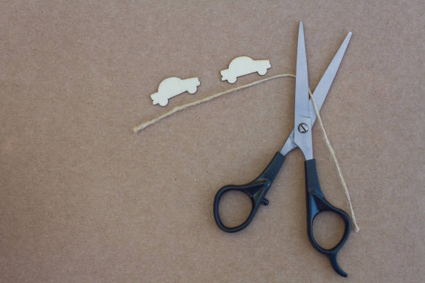 Direct above shot of scissors, measuring tape, threads and buttons on a table.
