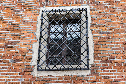 Window with Grate on Brick Wall Background.